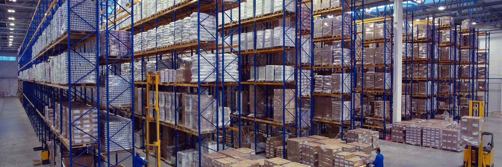 Magazzino aziendale con alte scaffalature piene di merce imballata