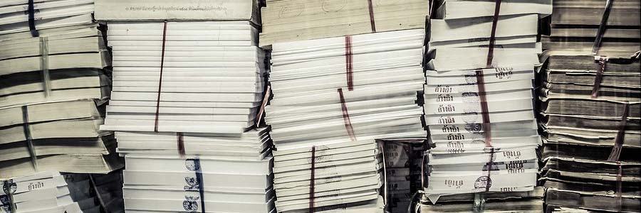 Pile di faldoni e documenti cartacei accatastati, pronti per la distruzione certificata